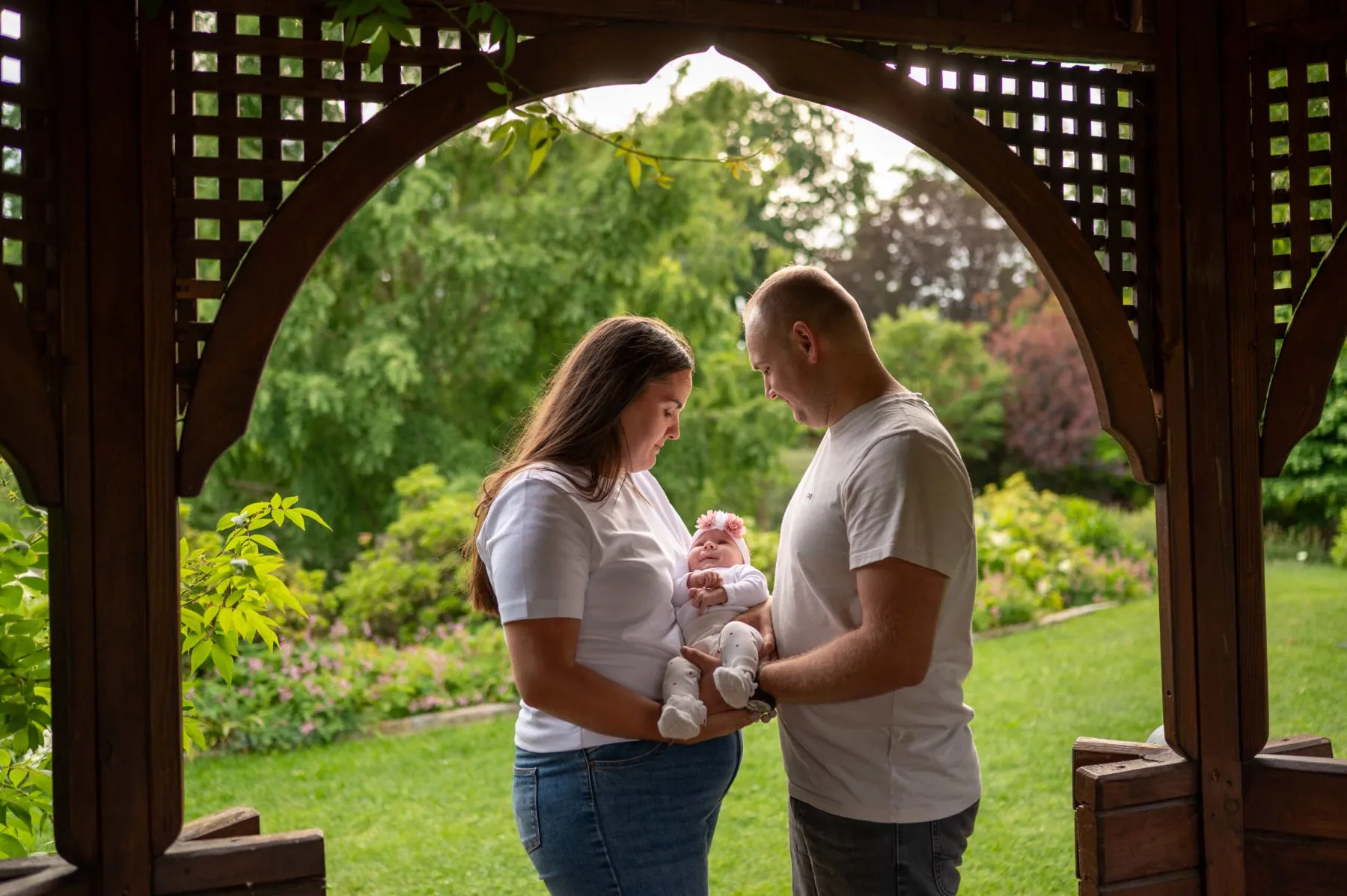 Rodzice z niemowlęciem w drewnianej altanie w arboretum