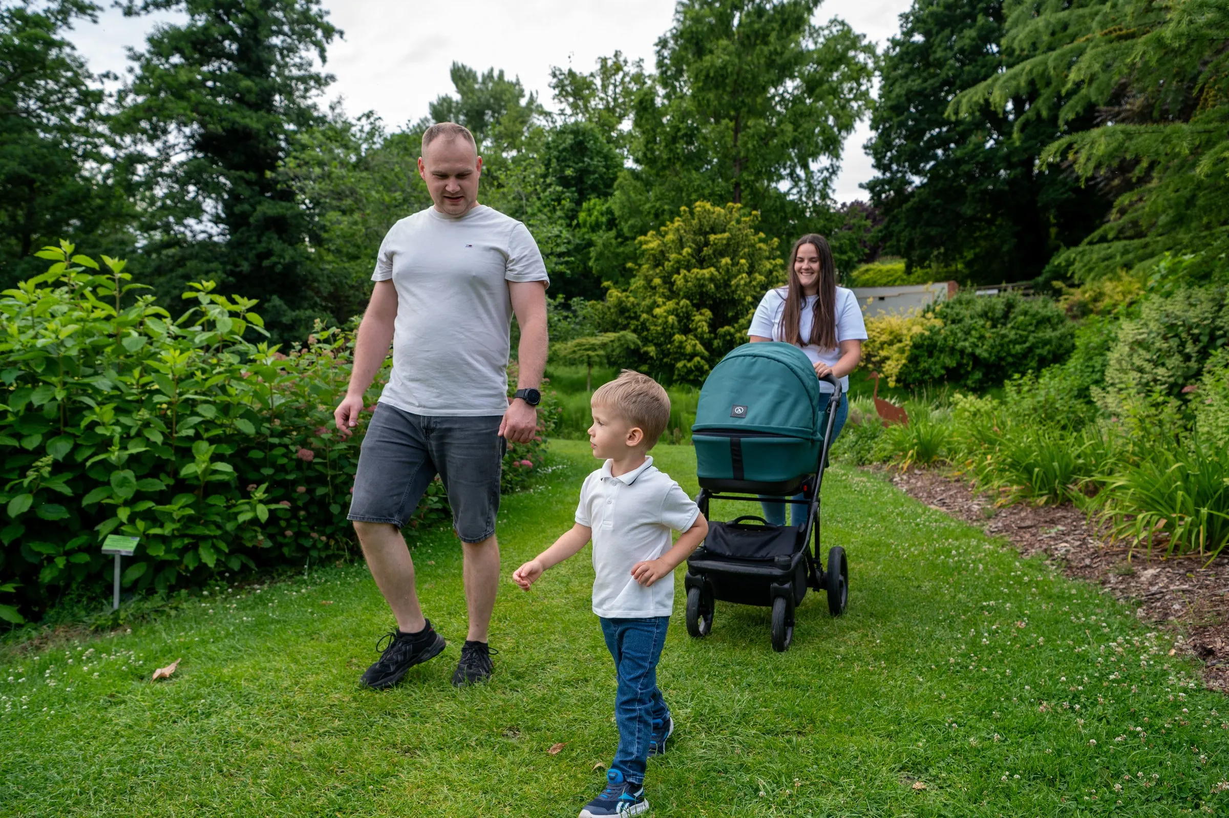 Spacer rodzinny z wózkiem alejką arboretum