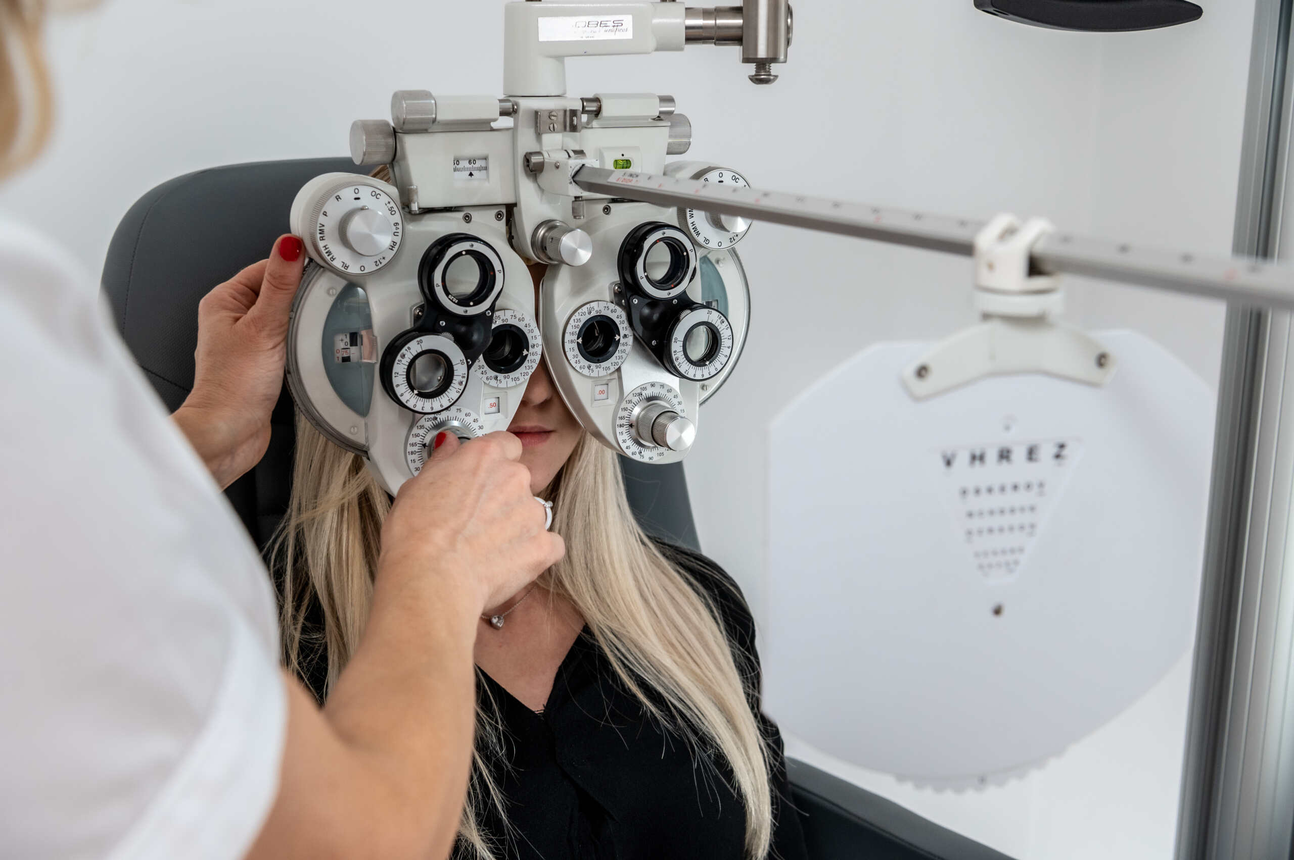 Optometrystka przeprowadzająca badanie ostrości wzroku w gabinecie optycznym